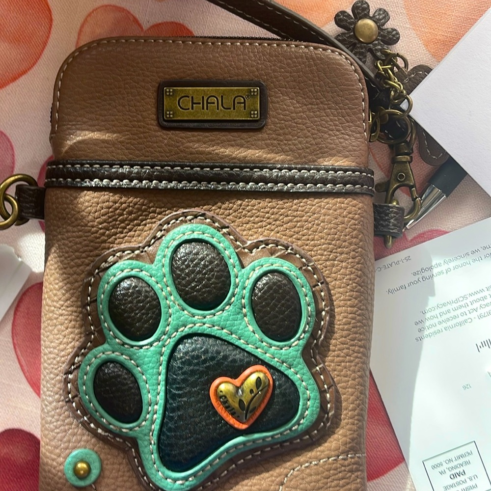 Cell phone ,car keys and has for credit cards 
Paw print on front
